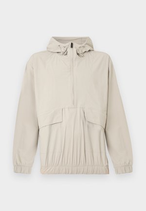 Ανοιχτό μπεζ πουλόβερ μπουφάν με κουκούλα, μπροστινό φερμουάρ έως τη μέση, ελαστικά μανίκια και ρυθμιζόμενο κορδόνι στη μέση. Διαθέτει μπροστινή τσέπη και λεία υφή.