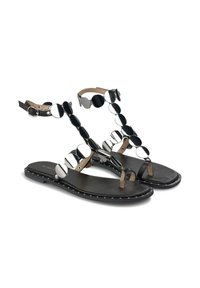 Černé ploché sandály s thong designem, zdobené kulatými kovovými akcenty v stříbrné a černé barvě, se detaily s hroty na okrajích.