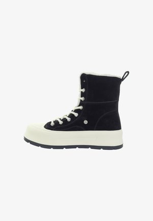 Czarne botki zamszowe do kostki z białym, sztucznym futerkiem w środku, białym gumowym noskiem i grubą czarną podeszwą. Wyposażone w jasne białe sznurówki i metalowe oczka.