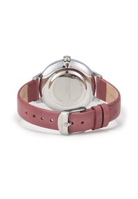 Montre en acier inoxydable avec un bracelet en cuir rose. Le dos présente un marquage gravé et une finition polie. Fermeture à boucle avec plusieurs trous.