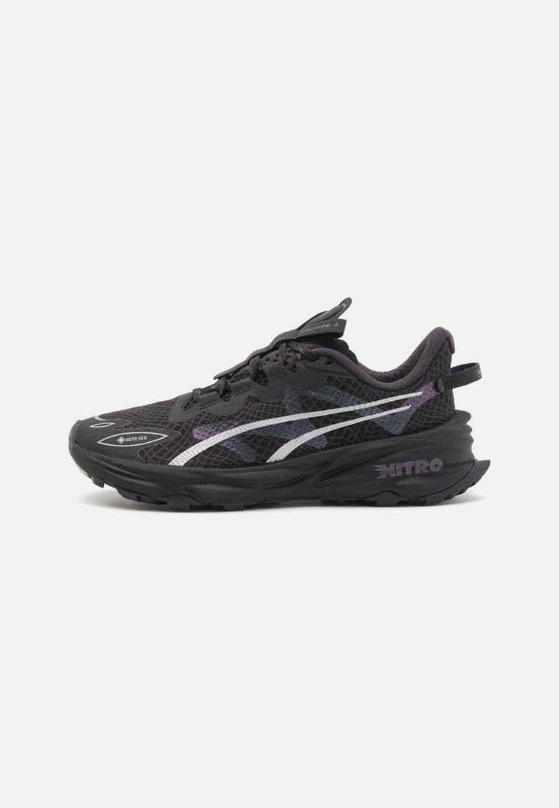 Baskets de course noires avec une tige en mesh, présentant un design violet et blanc, des lacets proéminents et une épaisse semelle en caoutchouc marquée "NITRO."