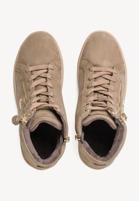 Baskets montantes en daim beige avec une finition texturée, dotées de lacets et d'accents en zipper doré sur les côtés pour un détail supplémentaire.