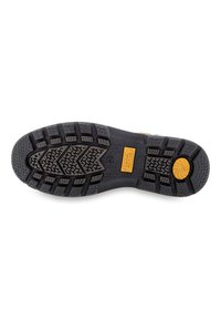 Black rubber shoe sole with deep tread patterns. Features a yellow accent with the brand logo “camel active” and size label “42.”