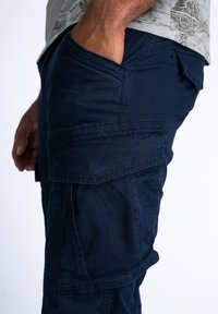 Marine cargoshorts gemaakt van duurzaam materiaal, met meerdere zakken, een ontspannen pasvorm en gestikte naden voor structurele integriteit.