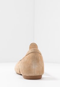 Jasnofioletowe zamszowe baleriny z zaokrąglonym tyłem i niską, gładką podeszwą, z delikatnym szwem wzdłuż pięty.