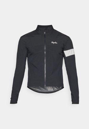 Sorte sykkeljakke laget av lett materiale. Har hel glidelås, høy krage, lange ermer og en reflekterende stripe på armen.
