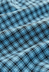 Tessuto a quadri blu chiaro con un motivo a scacchi e linee nere, che presenta una texture morbida e dettagli tessuti.