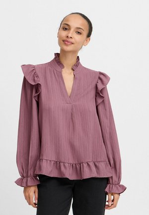 Ruffled long-sleeve blouse in muted mauve, featuring a deep V-neck, textured fabric, and a ruffled hem and cuffs.