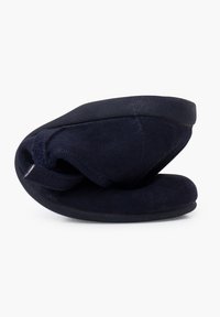 Zapatillas de color azul marino hechas de suave ante con forma redondeada, que cuentan con una suela de goma negra sólida y un diseño plegado para un almacenamiento compacto.