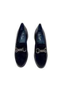 Scarpe slip-on nere in suede con finitura liscia, dotate di un elegante motivo a catena argentata sul davanti e un interno imbottito.