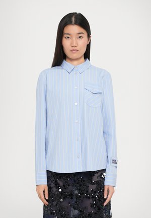 Lichtblauw button-up shirt met gele strepen, een borstzak en details op de manchetten. Het materiaal is glad en heeft een kraag.