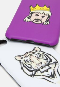 Purple and white phone cases with distinct graphics: a crowned figure on the purple case and a stylized tiger face on the white case.