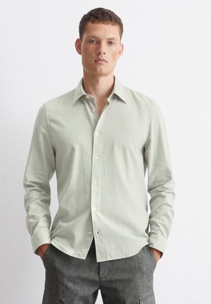 Light green patterned button-up shirt with long sleeves, a collar, and a straight hem. Features a subtle check design and white buttons.