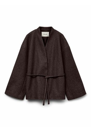 Brūna vilnas atvērta jaka ar plašām piedurknēm un plānu jostu, kas sasieta viduklī, apkaklī ir uzraksts "AWARE".