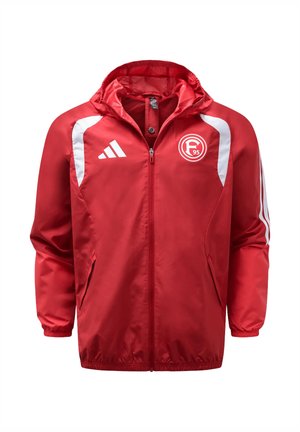 Czerwona kurtka sportowa z białym logo Adidas i emblematem F95, z przodu zamek błyskawiczny, kaptur, elastyczne mankiety oraz białe paski na ramionach i rękawach.