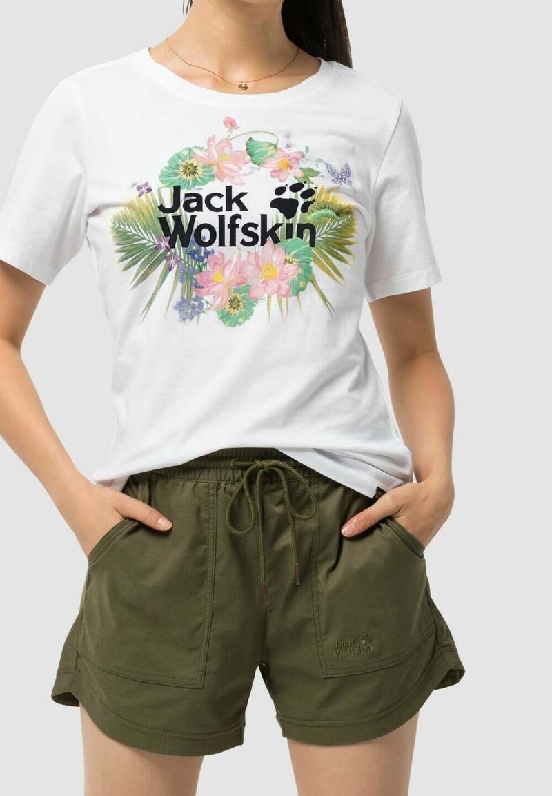 Camiseta blanca con un estampado colorido de flores y logo, combinada con pantalones cortos verde oliva con cintura elástica y bolsillos.