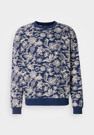 Sweat-shirt bleu marine avec broderie florale blanche, col rond, manches longues, poignets et ourlet côtelés, présentant des motifs botaniques détaillés.