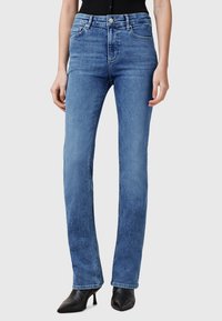Lichtblauwe denimspijkerbroek met een rechte pijp, vijf zakken, ritssluiting en een klassieke knoopsluiting. Glad textuur met vervagingdetails.