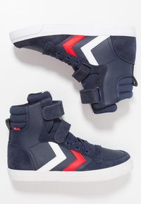 Zapatillas altas navy con correas de velcro, que presentan un diseño de chevron en blanco y rojo, materiales de ante y cuero sintético, y suela de goma.