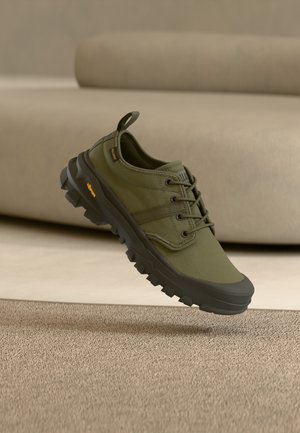 Olive green outdoor shoe with textile upper, rubber sole, and textured tread. Features five eyelets, a pull tab, and a reinforced toe.