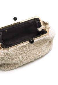 Borsa in stoffa color crema testurizzata con una cornice dorata e manopole nere, dotata di rivestimento nero e di una tasca interna con zip.