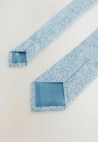Cravate à motifs floraux bleus avec de petits points d'accent orange, présentant une texture lisse semblable à de la soie et des extrémités carrées.