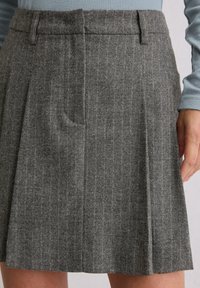 Grijze geplooide rok met subtiele streepjes, voorzien van een platte tailleband en zijzakken, gemaakt van textielwol.