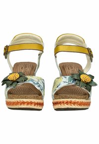 Hakken sandaal met een bloemaccent, gele enkelband, bovenwerk met een veelkleurig patroon, kurken voetbed en een gevlochten jute platform met oranje details.