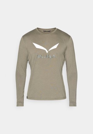 Long-sleeve shirt in light olive green, made of soft fabric. Features a large white "SALEWA" logo and sharp wing-like accents at the chest.