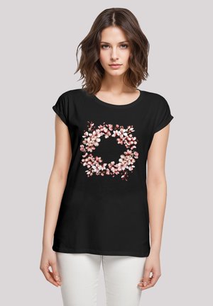 Schwarzes T-Shirt mit floralem Druck, das rosa Blumen in einer kreisförmigen Anordnung zeigt. Kurzärmlig und mit lockerer Passform.