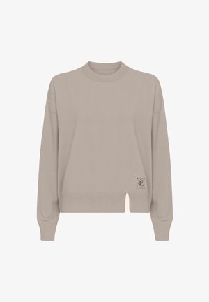 Maglione beige chiaro con collo rotondo, polsini a costine e spacco laterale. Presenta un'etichetta sulla parte anteriore con dettagli minimalisti. Tessuto morbido.
