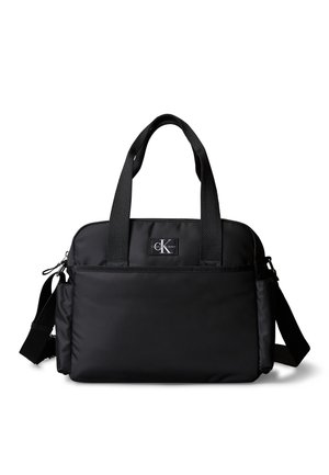 Czarna torebka Calvin Klein na ramię i do ręki z przednią kieszenią, dwoma uchwytami i regulowanym paskiem na białym tle.