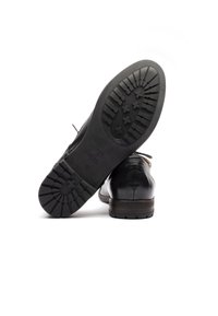 Scarpe da donna in pelle nera con un design elegante. Suole in gomma spesse con battistrada sagomato per una migliore aderenza. Il tallone è leggermente sollevato. Taglia 37.