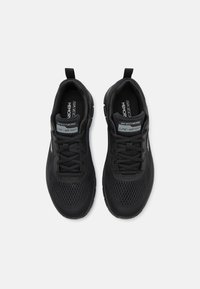 Black athletic shoes with a lightweight mesh upper, textured design, and lace-up closure. Features "Skechers" branding and memory foam insole.