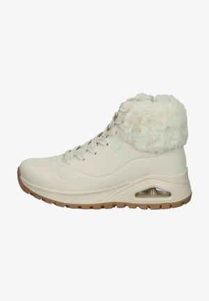 Białe wysokie sneakersy z sztucznym futerkiem na kołnierzu, teksturowana cholewka, sznurowane zapięcie oraz amortyzowana podeszwa z widoczną kieszenią powietrzną.