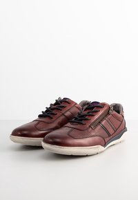 Scarpe in pelle marrone con dettagli perforati, superficie texturizzata, punta rotonda e lacci blu. Presentano una cerniera laterale per un accesso facile.