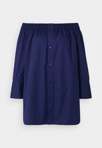 Camicia scollata blu navy realizzata in tessuto leggero. Presenta una chiusura con bottoni, un colletto elastico e maniche lunghe leggermente a sbuffo.
