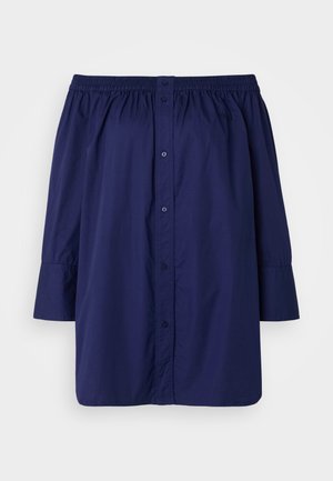 Marineblaue Off-Shoulder-Bluse aus leichtem Stoff. Verfügt über eine Knopfverschluss, einen elastischen Halsausschnitt und lange, leicht gepuffte Ärmel.