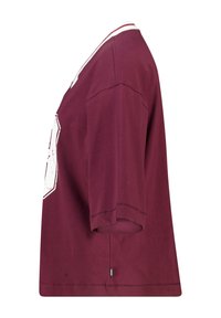 T-shirt en coton bordeaux à coupe ample, manches courtes et encolure ronde. Doté d'un motif graphique blanc sur le devant.