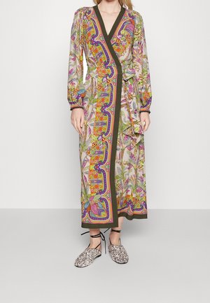 Long floral wrap dress with vibrant orange, purple, and green patterns, long sleeves, and black ankle-tie floral flats on a standing person.