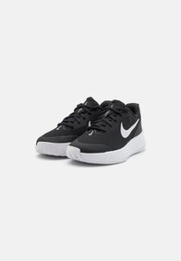 Čierne športové topánky s textúrovaným zvrškom, bielym logom Nike a kontrastnou bielou podrážkou. Obsahujú šnúrky a sú ľahké.