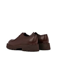 Scarpe in pelle marrone con punta arrotondata, suola marrone spessa e testurizzata, e dettagli di cucitura minimi sulla tomaia.