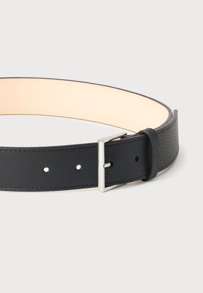 Ceinture en cuir noir texturé avec boucle rectangulaire argentée et deux trous de réglage, présentée sur un fond clair.