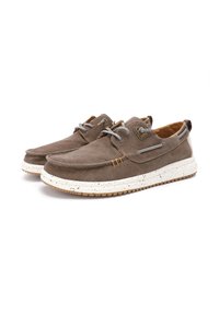 Scarpe in tela marrone con superficie texturizzata, suola in gomma bianca maculata, lacci grigi e un accento in tessuto marrone sul tallone.