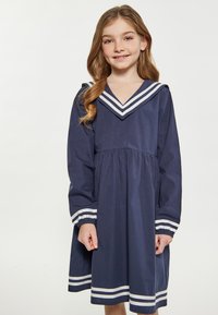 Navyblaues Baumwollkleid mit einem Matrosenkragen, der weiße Streifen am Kragen und an den Ärmeln aufweist, sowie einer gerafften Taille für eine lockere Passform.
