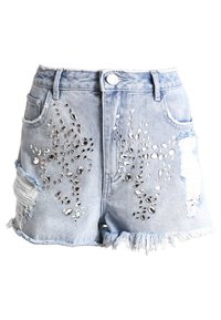 Vaaleansiniset farkkushortsit, joissa on kuluneita yksityiskohtia, repsottava helma ja koristeelliset hopeiset strassikoristeet edessä.