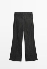 Pantaloni flared in denim nero con vita alta, dotati di due tasche posteriori e una texture liscia. Cuciture visibili lungo le cuciture.