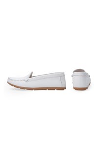Weisse Leder-Slipper mit niedrigem Profil, abgerundeter Zehenpartie, kontrastierender Gummisohle und dekorativer Stickerei entlang der Kante.