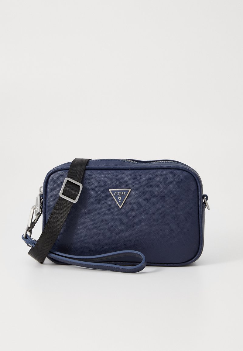 Navy blue rectangular bag made of textured material; features a black adjustable strap, silver hardware, and a triangular logo accent.