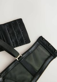 Čierny nastaviteľný popruh s odvetrávanou látkou, kovovými prvkami a viacerými suchými zipsami pre bezpečné upevnenie a správne prispôsobenie.